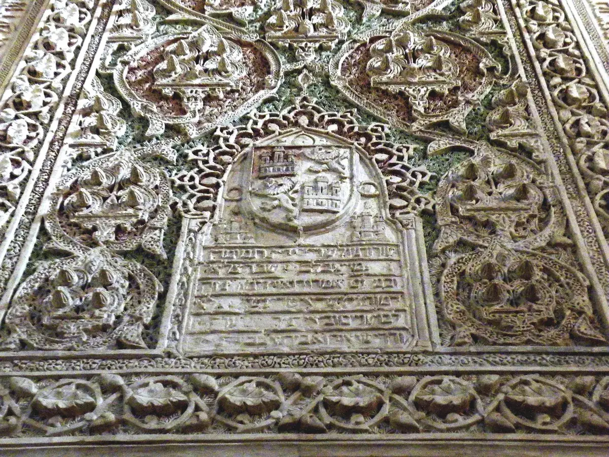 Interior de la Sinagoga del Tránsito de Toledo, con yeserías talladas e inscripciones hebreas.